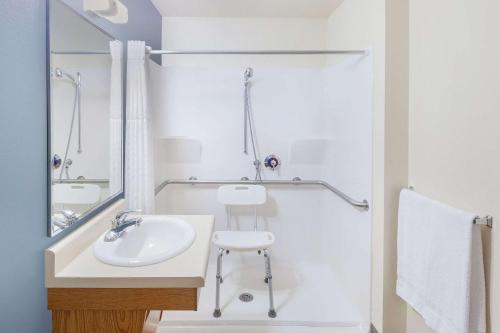 アンケニーにあるWoodSpring Suites Ankeny Des Moinesの洗面台とシャワー付きの白いバスルーム