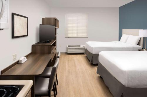 a hotel room with two beds and a desk at WoodSpring Suites Miami Southwest in Kendall