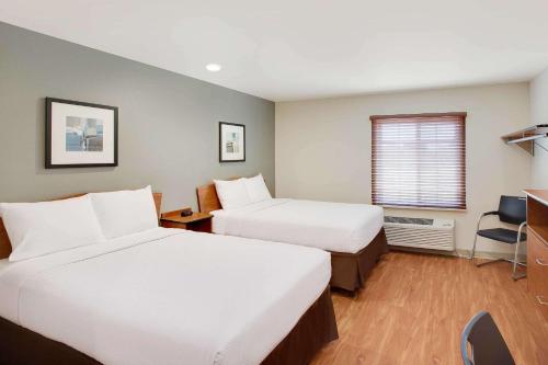 a hotel room with two beds and a window at WoodSpring Suites Lake Charles in Lake Charles