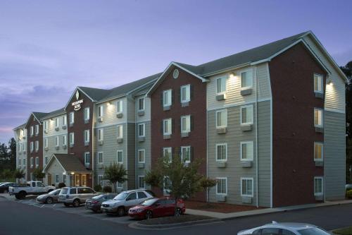 a large building with cars parked in a parking lot at WoodSpring Suites Charlotte Gastonia in Gastonia