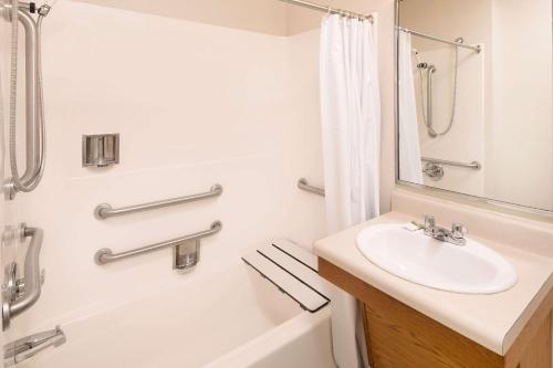 La salle de bains est pourvue d'un lavabo, d'une douche et d'une baignoire. dans l'établissement WoodSpring Suites Charlotte Gastonia, à Gastonia