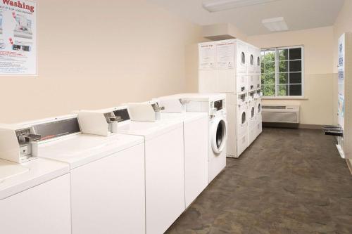 a laundry room with white washing machines and a window at WoodSpring Suites Charlotte Gastonia in Gastonia