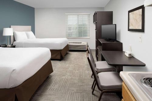 Habitación de hotel con 2 camas y escritorio en WoodSpring Suites Murfreesboro en Murfreesboro
