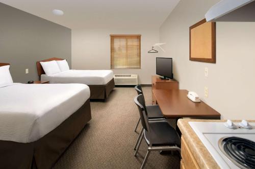 a hotel room with two beds and a desk at WoodSpring Suites Memphis East I-40 in Memphis