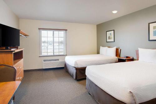 Habitación de hotel con 2 camas y TV en WoodSpring Suites Chesapeake-Norfolk Greenbrier en Chesapeake
