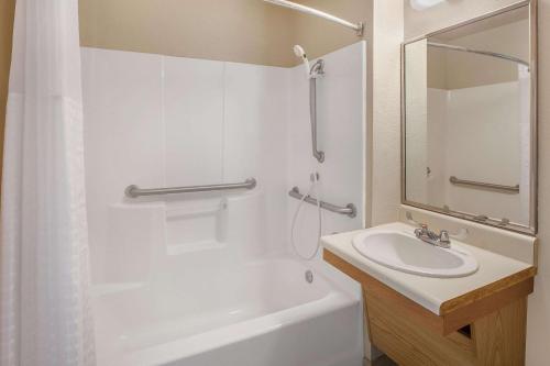 a white bathroom with a sink and a shower at WoodSpring Suites Waco near University in Waco