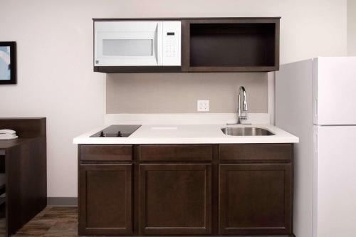 a kitchen with a sink and a microwave at WoodSpring Suites Austin South Central I-35 in Austin