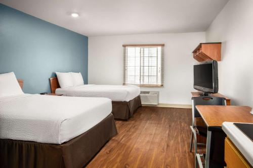 a hotel room with two beds and a flat screen tv at WoodSpring Suites Clarksville Ft. Campbell in Clarksville