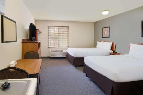 a hotel room with two beds and a sink at WoodSpring Suites Richmond West I-64 in Richmond