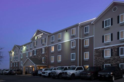 a large building with cars parked in a parking lot at WoodSpring Suites Midland in Midland