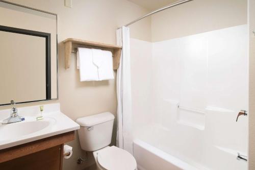 a bathroom with a sink and a toilet and a bath tub at WoodSpring Suites Midland in Midland