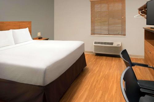 a bedroom with a bed and a desk and a chair at WoodSpring Suites San Angelo in San Angelo