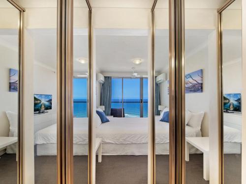 a mirror in a bedroom with a view of the ocean at Peninsula 21b in Gold Coast