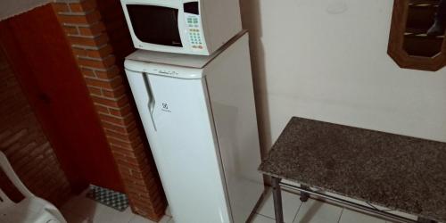 a microwave sitting on top of a refrigerator at Pousada Danza - Centro in Poços de Caldas