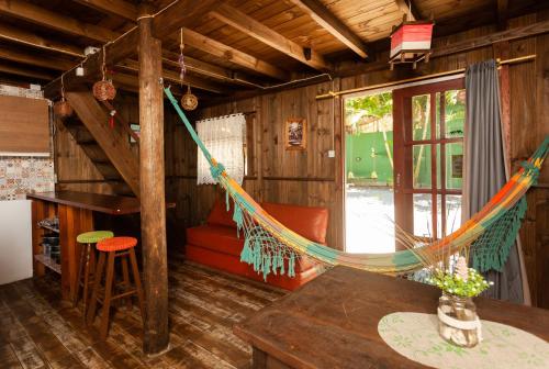 a room with a hammock in a cabin at Recanto do Sossego in Garopaba