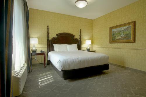 a hotel room with a bed and two lamps at Azure Hotel&Suites Ontario Trademark Collection by Wyndham in Ontario