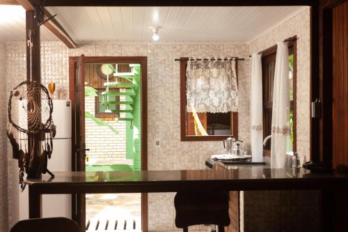 a kitchen with a table and a refrigerator at Recanto do Sossego in Garopaba