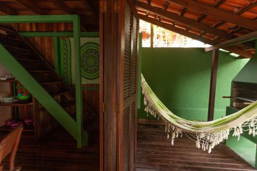 a hammock in a room with a green wall at Recanto do Sossego in Garopaba