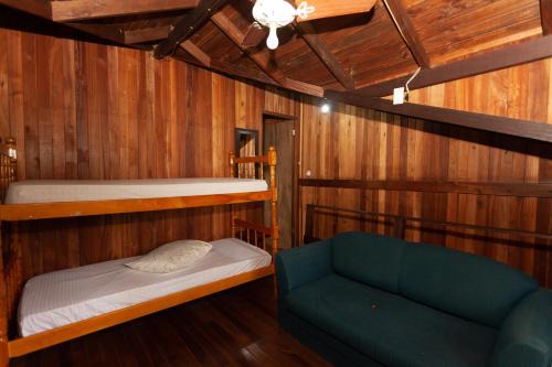 a room with two bunk beds and a couch at Recanto do Sossego in Garopaba