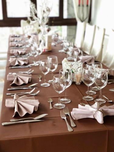 a long table with wine glasses and napkins on it at Hotel Complex Turistic Magura in Măgura
