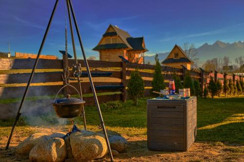 a pot over a fire in a yard with a fence at Domy na Spiszu in Czarna Góra