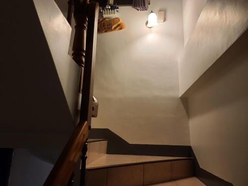 a stairway with a light on the wall and a stair case at Fire B&B in Chishang
