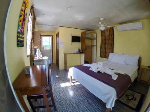 una camera d'albergo con letto e scrivania di Chila's Accommodations a Caye Caulker