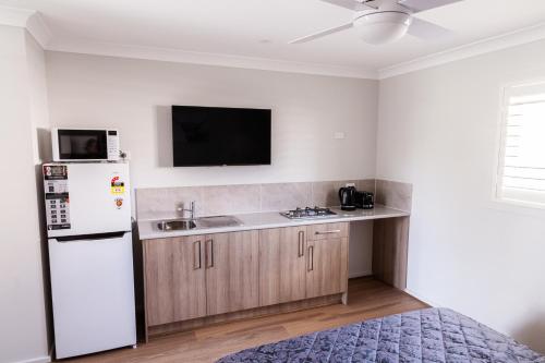 a kitchen with a white refrigerator and a sink at Singleton Valley Accommodation in Singleton