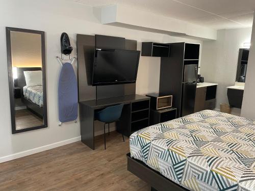 a bedroom with a bed and a desk with a television at Studio 6 Vicksburg, MS- Downtown in Vicksburg