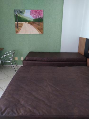 two beds in a room with a picture on the wall at 504-AP-com bebidas liberadas no parque aquatico e internet banda larga in Caldas Novas