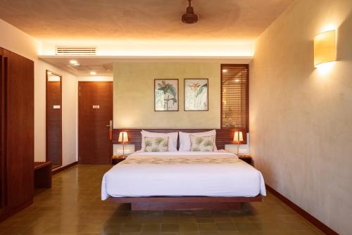 a bedroom with a large bed with two lamps at Penh House Hotel in Phnom Penh