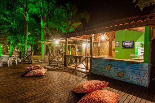 a bar with pillows on a wooden deck at night at Recanto do Sossego in Garopaba
