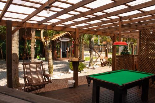 a pool table on a deck with a pergola at Recanto do Sossego in Garopaba