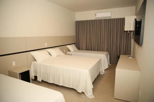 ウムアラマにあるRaf Hotelのベッド2台とテレビが備わるホテルルームです。