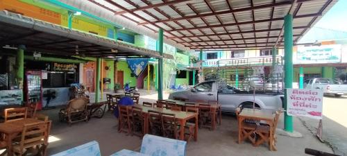 a restaurant with tables and chairs and a car parked on the street at RuengsriSiri Guesthouse in Sukhothai
