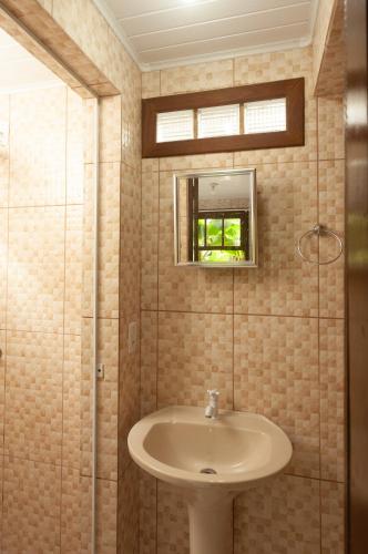 a bathroom with a sink and a mirror at Recanto do Sossego in Garopaba