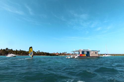 a person is windsurfing on the water with a boat at Aqualodge Guadeloupe in Saint-François