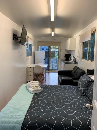 Cet appartement comprend une chambre avec un lit, un salon et une cuisine. dans l'établissement Wine Country Tourist Park Hunter Valley, à Nulkaba