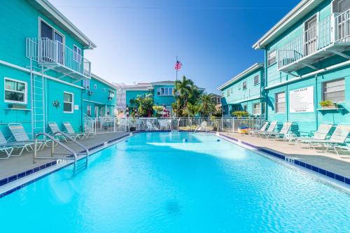 a swimming pool in front of a building with chairs at Cute One Bedroom at The Coral Resort apts in Clearwater Beach