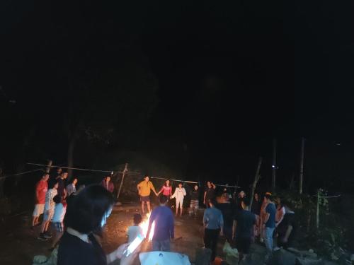 un grupo de personas de pie alrededor en la oscuridad en Hoàng Công Bản Giốc Homestay, en Cao Bằng