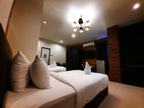 a hotel room with two beds and a chandelier at Debua Mahasarakham in Maha Sarakham