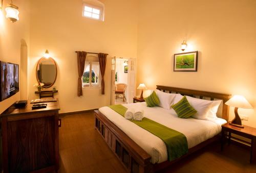 1 dormitorio con 1 cama grande y espejo en Teanest Nightingale by Nature Resorts, en Kotagiri