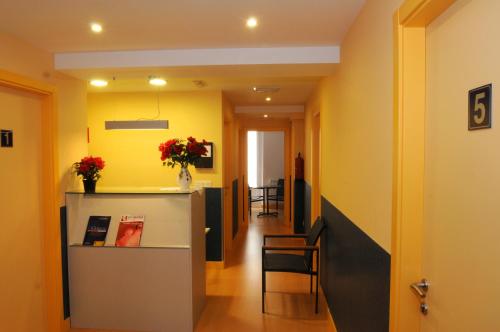 a hallway with a room with yellow walls and a table and chairs at Pensión la Marinera in San Sebastián