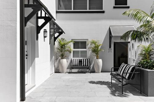 a patio with two benches in front of a building at St Marks Randwick in Sydney