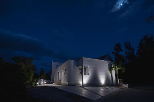 a white building with lights on it at night at Okinawa Villa KILOHANA in Inbu