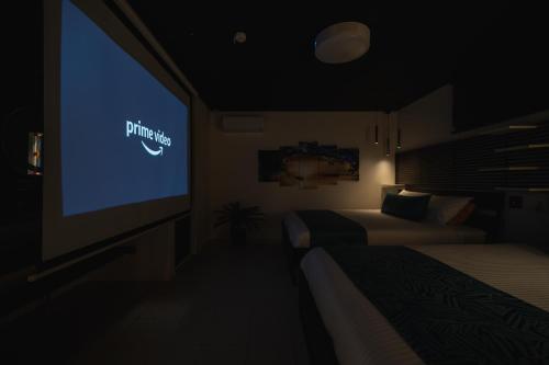 a room with two beds and a tv with a nike sign at Okinawa Villa KILOHANA in Inbu