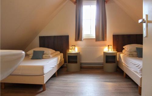 a attic room with two beds and a window at Tsjep in De Bult