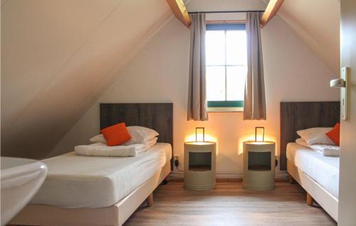 德布爾特的住宿－Nocht，阁楼卧室配有两张床和两盏灯。