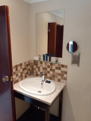 ein Badezimmer mit Waschbecken und Spiegel in der Unterkunft Avalon Springs Resort in Montagu