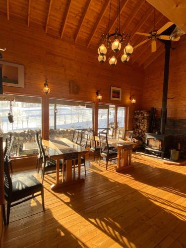 a dining room with tables and chairs and a fireplace at Ritz Garden Niji in Biei